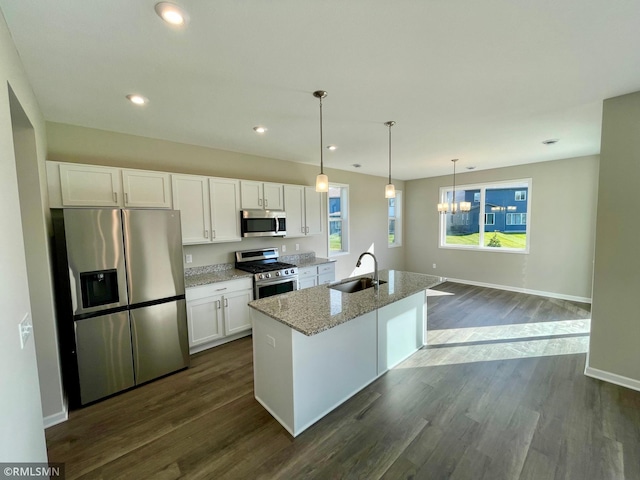 9955 Bluebird St NW, Coon Rapids, MN 55433 - kitchen with stainless steel appliances, a sink, white cabinets, dark wood finished floors, and light stone counters