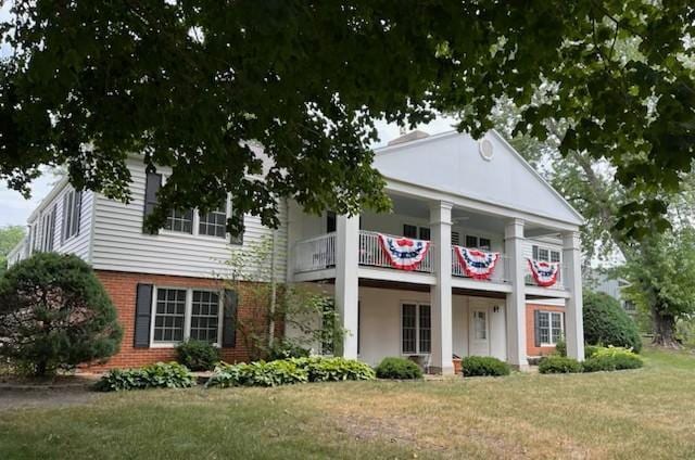 331 Willamor Cir, Albert Lea, MN 56007 - neoclassical home with a balcony, a front lawn, and brick siding