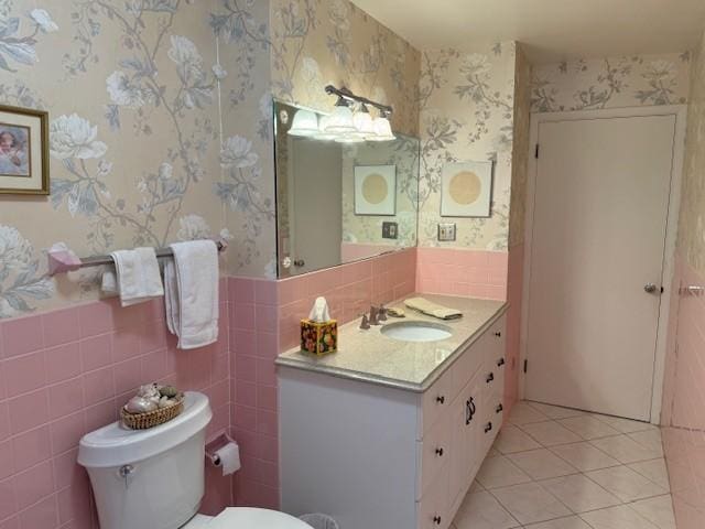 331 Willamor Cir, Albert Lea, MN 56007 - half bathroom featuring wallpapered walls, vanity, toilet, tile patterned flooring, and tile walls