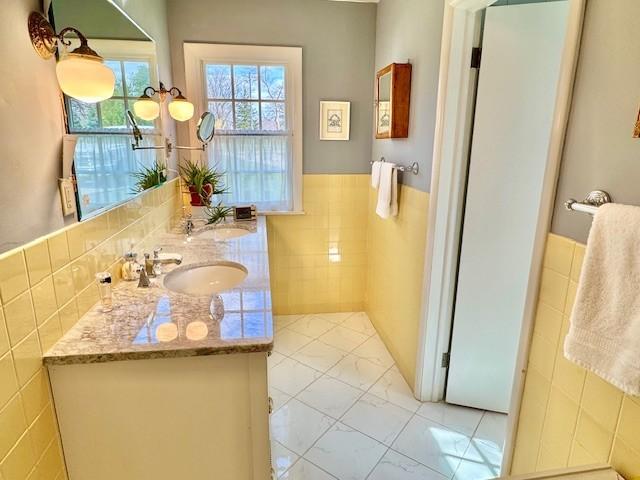 331 Willamor Cir, Albert Lea, MN 56007 - bathroom with tile walls, double vanity, and a wainscoted wall