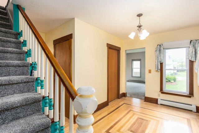 428 4th St, River Falls, WI 54022 - entryway featuring a chandelier, stairway, baseboards, and a baseboard radiator