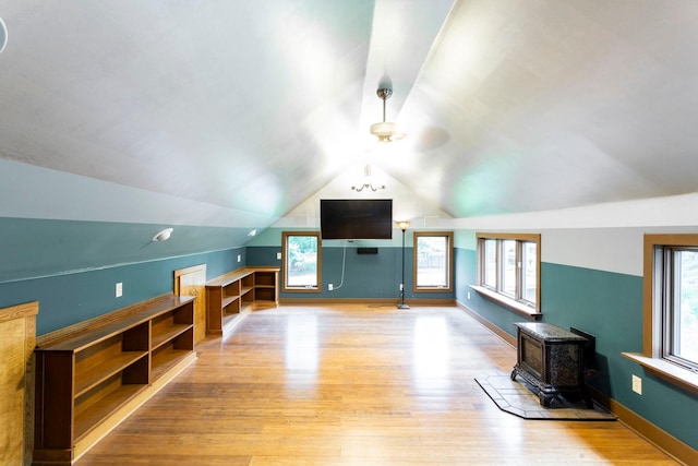 428 4th St, River Falls, WI 54022 - additional living space featuring light wood-style floors, vaulted ceiling, plenty of natural light, a wood stove, and a ceiling fan