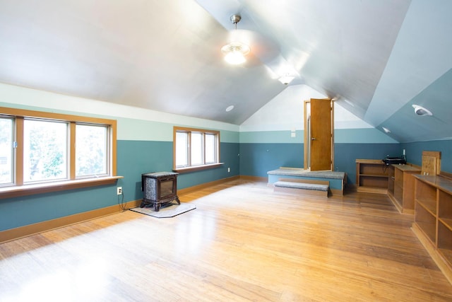 428 4th St, River Falls, WI 54022 - bonus room with a wood stove, vaulted ceiling, wood finished floors, and baseboards