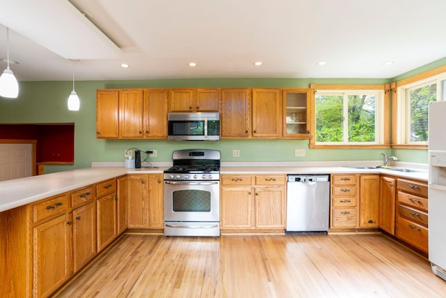 428 4th St, River Falls, WI 54022 - kitchen featuring stainless steel appliances, a sink, light countertops, light wood-type flooring, and recessed lighting