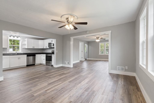 806 4th St, Marshall, MN 56258 - kitchen with stainless steel appliances, dark countertops, a ceiling fan, and open shelves