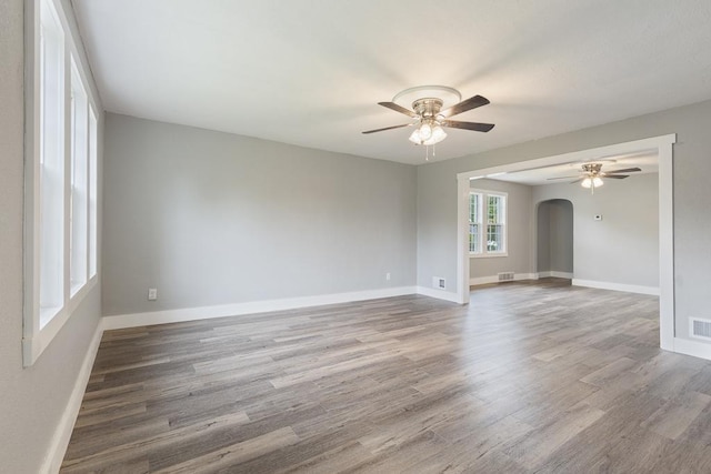 806 4th St, Marshall, MN 56258 - spare room with arched walkways, ceiling fan, wood finished floors, and baseboards