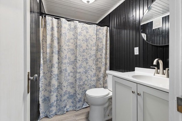 806 4th St, Marshall, MN 56258 - full bath featuring wood finished floors, toilet, vanity, wooden walls, and a shower with shower curtain