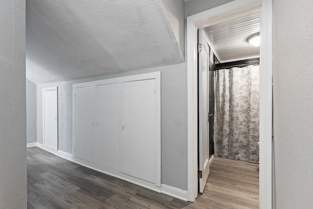 806 4th St, Marshall, MN 56258 - additional living space featuring wood finished floors, a textured wall, baseboards, and lofted ceiling