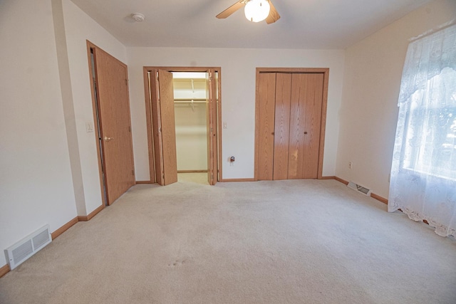 101 6th St NW, Perham, MN 56573 - unfurnished bedroom with light carpet, two closets, baseboards, and ceiling fan