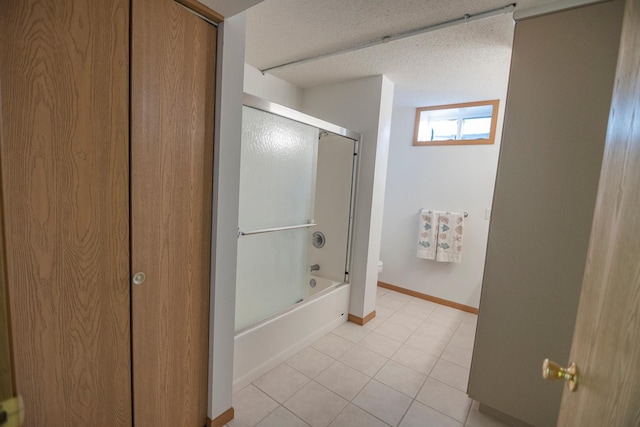 101 6th St NW, Perham, MN 56573 - full bath with toilet, baseboards, tile patterned floors, bath / shower combo with glass door, and a textured ceiling