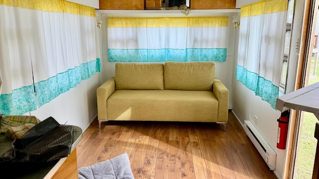25673 Happy Hollow Rd, Park Rapids, MN 56470 - sitting room featuring a baseboard heating unit, wood finished floors, and baseboards