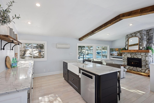168 1st St, Excelsior, MN 55331 - kitchen featuring a sink, stainless steel dishwasher, a wall unit AC, light wood-style floors, and a stone fireplace