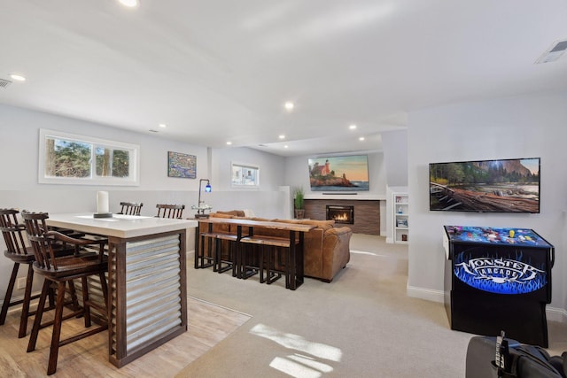 168 1st St, Excelsior, MN 55331 - kitchen with a lit fireplace, recessed lighting, light colored carpet, and baseboards