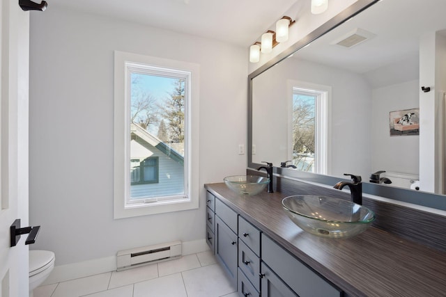 168 1st St, Excelsior, MN 55331 - full bath featuring a baseboard heating unit, toilet, double vanity, and tile patterned flooring