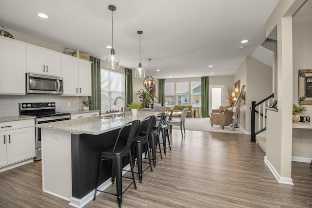 20555 Greenwood Ave, Lakeville, MN 55044 - kitchen with stainless steel appliances, a sink, light wood finished floors, healthy amount of natural light, and recessed lighting