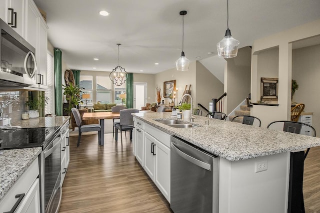 20555 Greenwood Ave, Lakeville, MN 55044 - kitchen with stainless steel appliances, a sink, light wood-style flooring, an island with sink, and recessed lighting