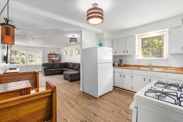 180 Saint Croix Trl N, Lakeland, MN 55043 - kitchen with white appliances, a sink, light wood finished floors, and white cabinets