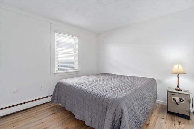 180 Saint Croix Trl N, Lakeland, MN 55043 - bedroom featuring a baseboard heating unit, wood finished floors, baseboards, and ornamental molding