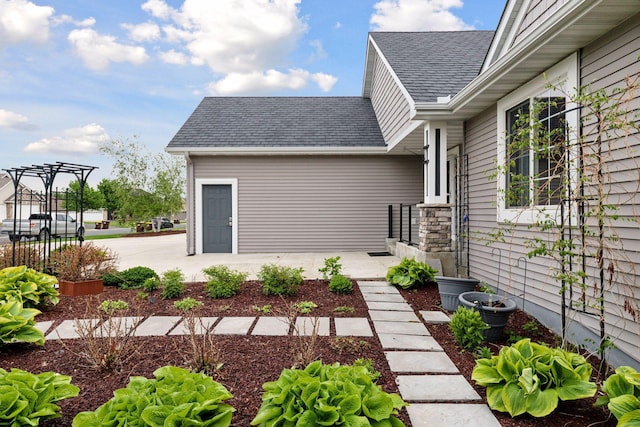 1429 10th Street Cir SE, New Prague, MN 56071 - doorway to property with a shingled roof and a patio area