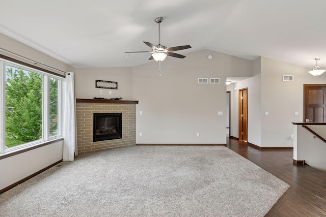 1429 10th Street Cir SE, New Prague, MN 56071 - unfurnished living room featuring lofted ceiling, baseboards, ceiling fan, a fireplace, and dark wood finished floors