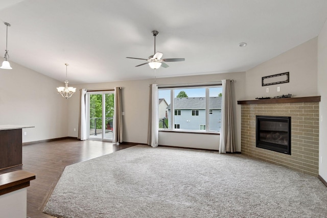 1429 10th Street Cir SE, New Prague, MN 56071 - unfurnished living room with a fireplace, a chandelier, a ceiling fan, wood finished floors, and baseboards