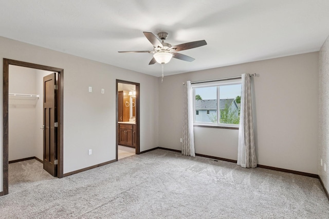 1429 10th Street Cir SE, New Prague, MN 56071 - unfurnished bedroom featuring light colored carpet, a walk in closet, baseboards, and ceiling fan