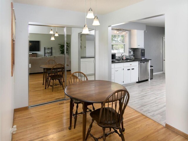 dining area with light wood-type flooring and baseboards