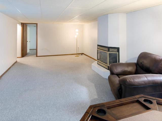 carpeted living room featuring baseboards and a multi sided fireplace