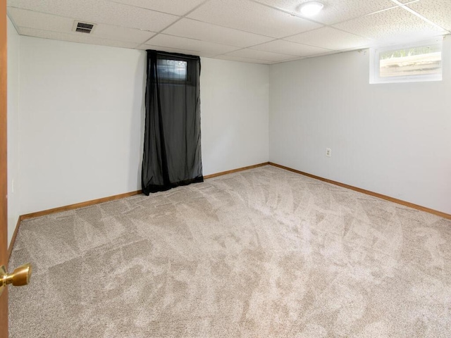 spare room with carpet, baseboards, and a drop ceiling