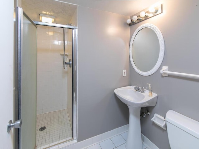 full bath featuring tile patterned floors, toilet, a shower stall, and a sink