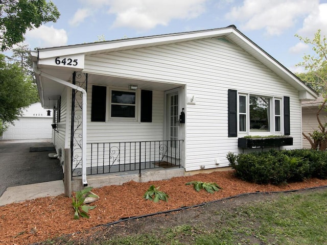 view of front of property featuring a porch and an outbuilding