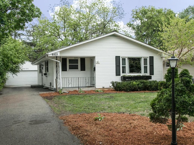 view of front of home with an outdoor structure, a porch, a front lawn, and a garage