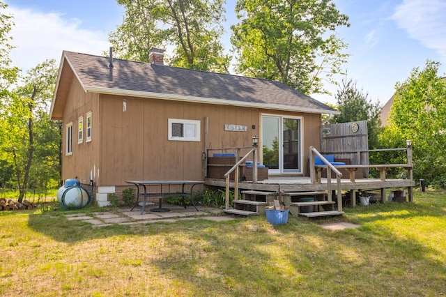 1605 White Ash Ln, Apple River Twp, WI 54810 - rear view of house featuring a deck, a lawn, a shingled roof, and a chimney