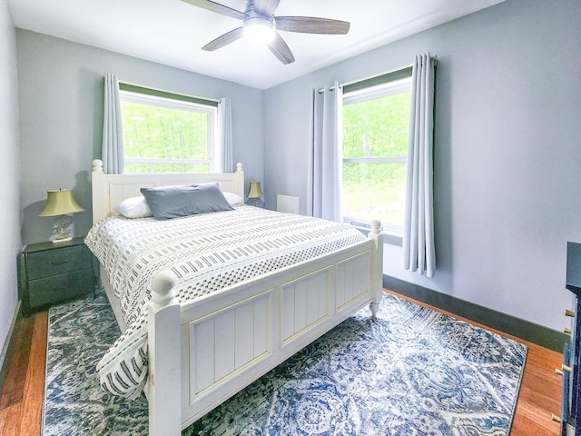 8586 Graves Lake Rd NE, Remer, MN 56672 - bedroom featuring multiple windows, wood finished floors, and ceiling fan