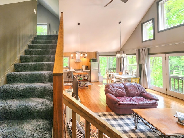 8586 Graves Lake Rd NE, Remer, MN 56672 - living area featuring high vaulted ceiling, light wood-style flooring, ceiling fan, plenty of natural light, and stairway