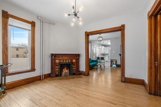 2744 Stevens Ave, Minneapolis, MN 55408 - living room with a chandelier, light wood-style floors, and baseboards