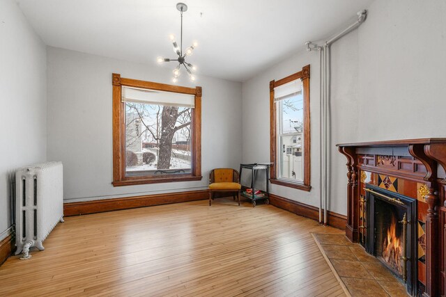2744 Stevens Ave, Minneapolis, MN 55408 - sitting room featuring radiator, plenty of natural light, a chandelier, and a tile fireplace