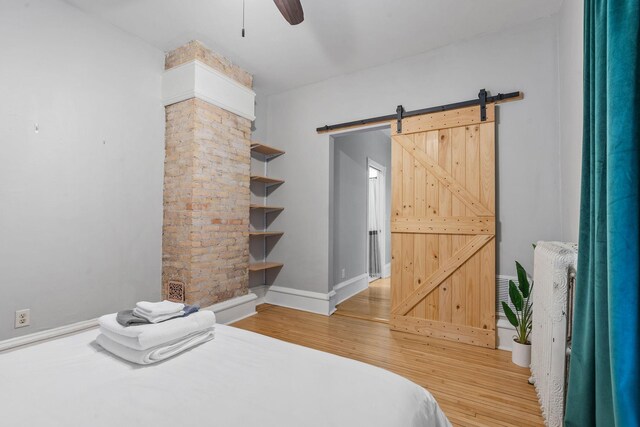 2744 Stevens Ave, Minneapolis, MN 55408 - bedroom featuring light wood-type flooring, a barn door, baseboards, and ceiling fan
