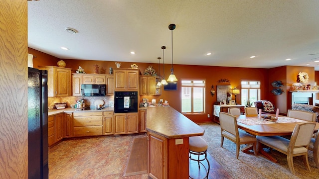 1720 Hale Dr, Albert Lea, MN 56007 - kitchen featuring black appliances, a peninsula, a breakfast bar area, light countertops, and recessed lighting