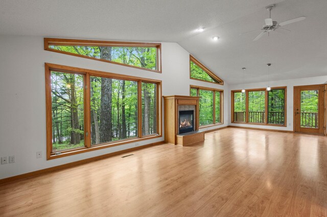 568 26th Ave, Cumberland, WI 54829 - unfurnished living room with a fireplace, high vaulted ceiling, light wood finished floors, baseboards, and a ceiling fan