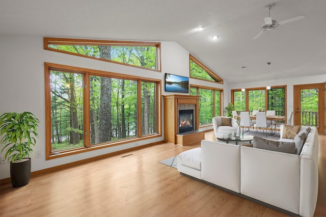 568 26th Ave, Cumberland, WI 54829 - living room featuring a fireplace, wood finished floors, high vaulted ceiling, ceiling fan, and baseboards