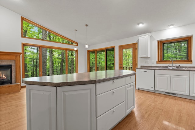 568 26th Ave, Cumberland, WI 54829 - kitchen featuring dishwasher, a sink, dark countertops, light wood-style floors, and vaulted ceiling