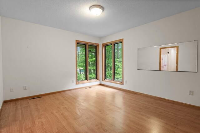 568 26th Ave, Cumberland, WI 54829 - spare room with wood finished floors, baseboards, and a textured ceiling