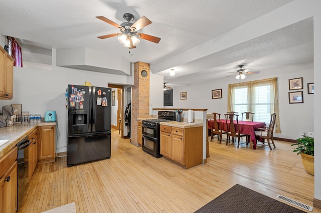658 Plum St, Saint Paul, MN 55106 - kitchen featuring black appliances, ceiling fan, light wood-type flooring, light countertops, and a textured ceiling