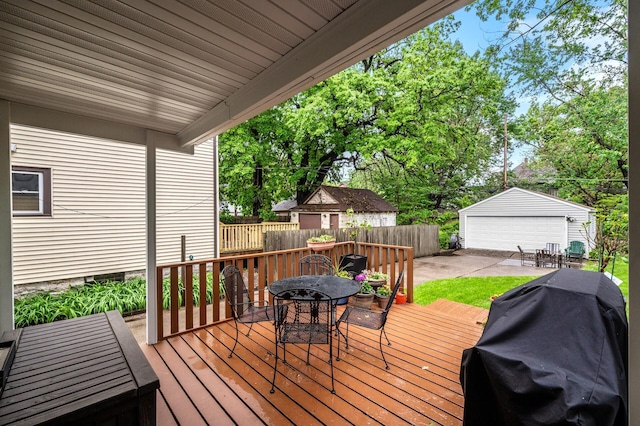 658 Plum St, Saint Paul, MN 55106 - wooden deck with outdoor dining space, a detached garage, a grill, and an outbuilding