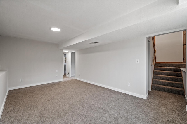 finished below grade area featuring carpet floors, stairway, and baseboards