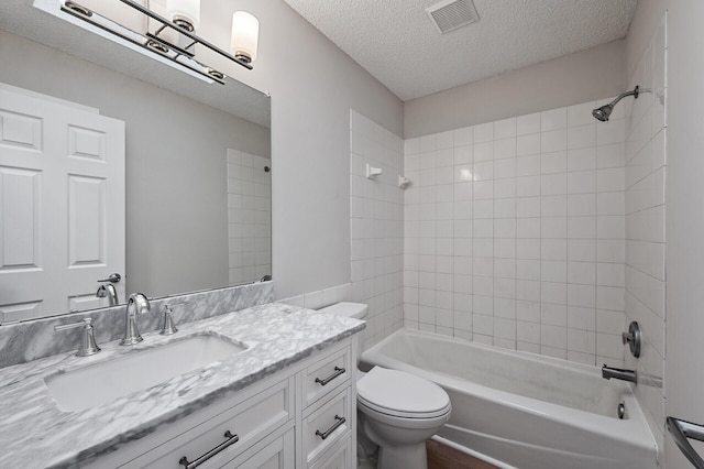 bathroom featuring a textured ceiling, toilet,  shower combination, and vanity