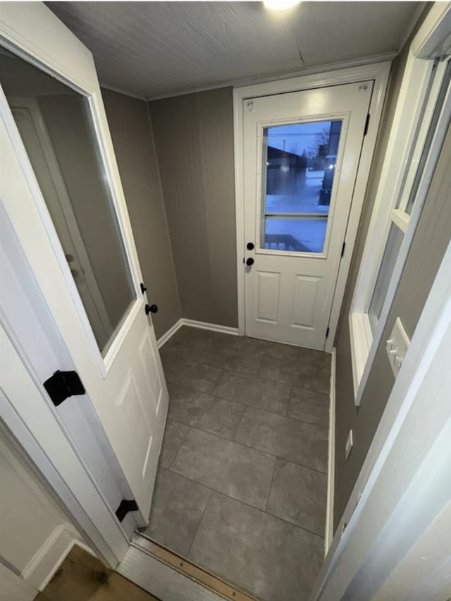 doorway featuring baseboards