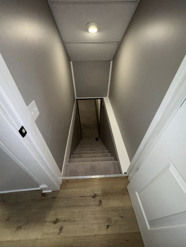 stairs featuring wood finished floors and baseboards
