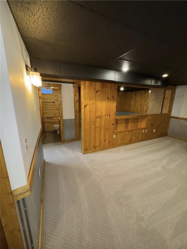 finished basement featuring carpet and wooden walls